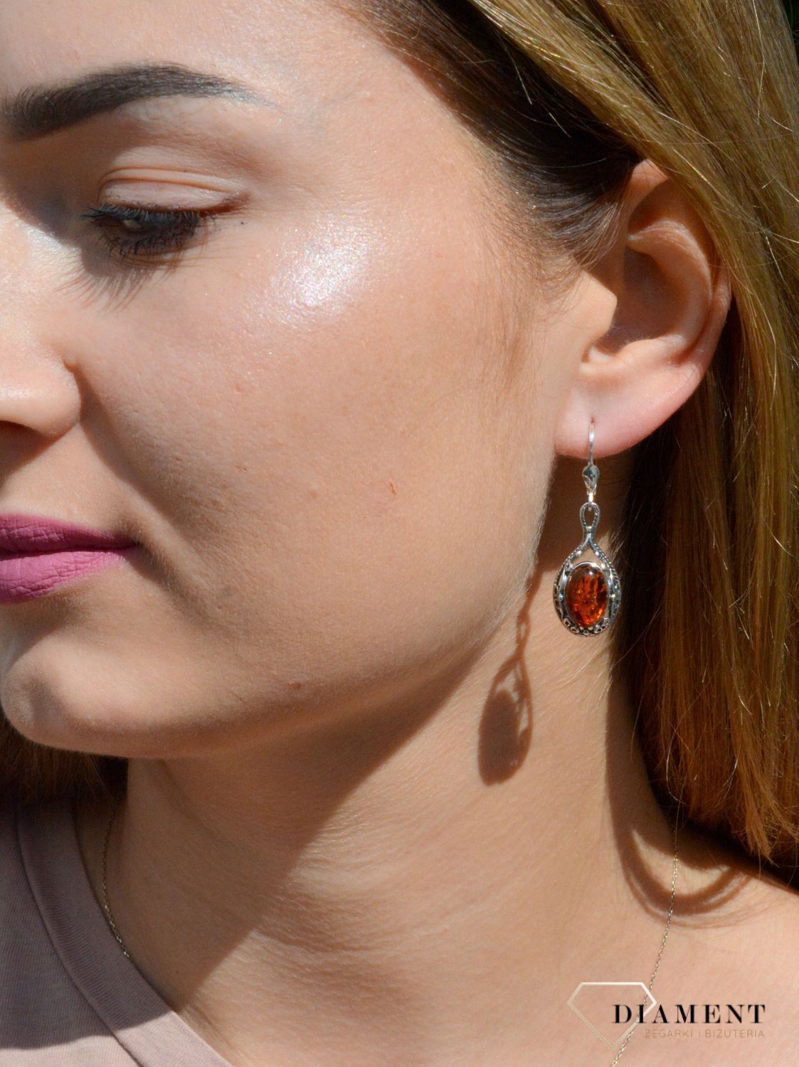 Kolczyki srebrne wiszące z owalnym bursztynem DIA-KLC-7101-925.  Srebrne kolczyki z bursztynem to modelem bardzo ciekawy, ponieważ dzięki ciepłej kolorystyce pięknie podkreśla on urodę. Charakteryzują się stylem wiszącym i są.jpg