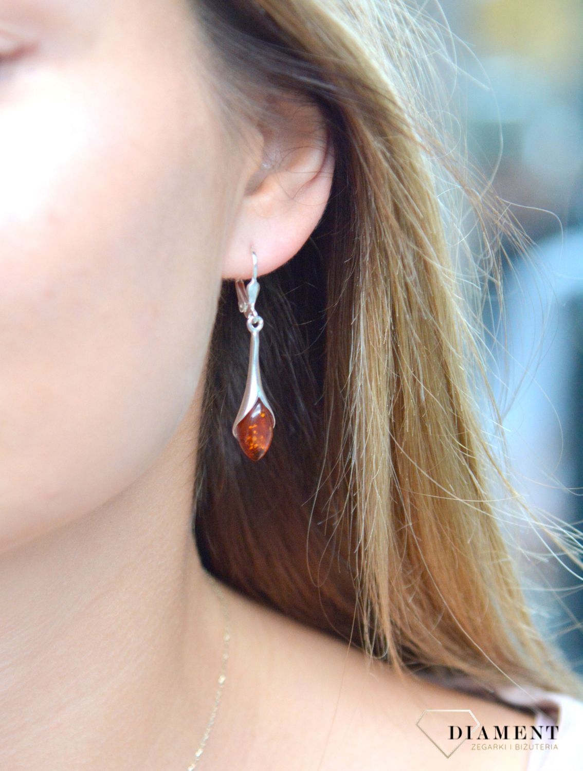 Srebrne kolczyki wiszące damskie z bursztynem DIA-KLC-7102A-925. Charakteryzują się stylem wiszącym i zawieszone są na tradycyjnych biglach angielskich. Srebrne kolczyki z bursztynem to modelem bardzo ciekawy, pięknie podkreś.jpg