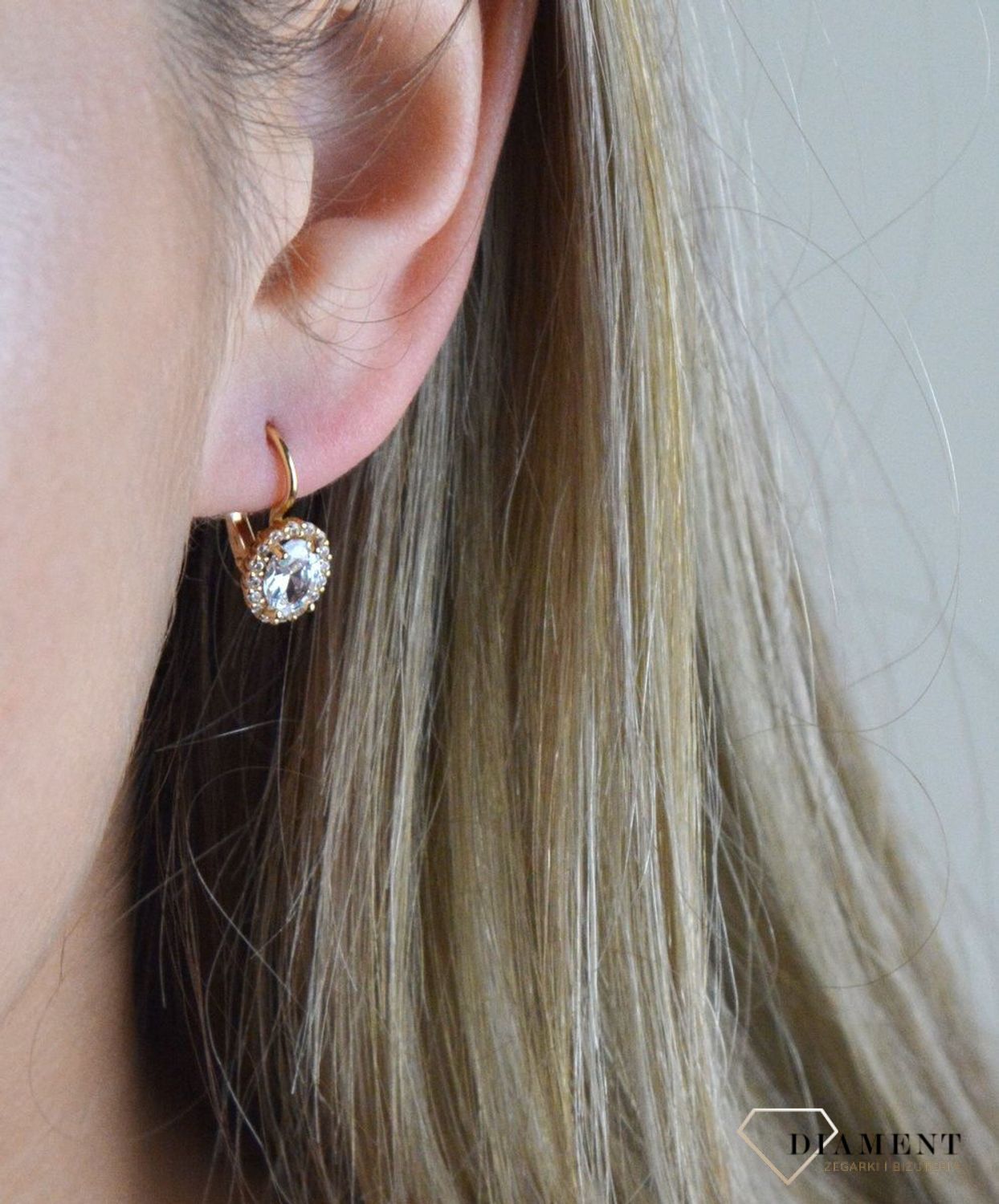 Złote kolczyki 375 wiszące z owalną cyrkonią DIA-KLC-7758-375. Kolczyki w minimalistycznym stylu, wpisujące się w obecne trendy modowe. Delikatna forma, najwyższej jakości złota to idealne uzupełnienie eleganckich stylizacji.jpg