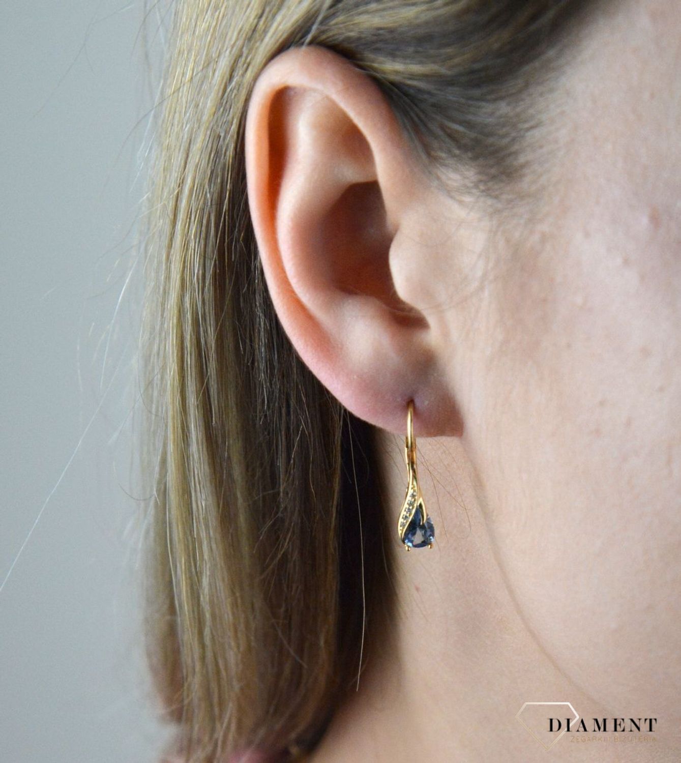 Złote kolczyki 375 wiszące łezki z błękitną cyrkonią DIA-KLC-7759-375. Złote kolczyki wykonane z najwyższej jakości żółtego złota, próba 375, waga około 2,06 gram. Kolczyki w minimalistycznym stylu, wpisujące się w obecne tren.jpg