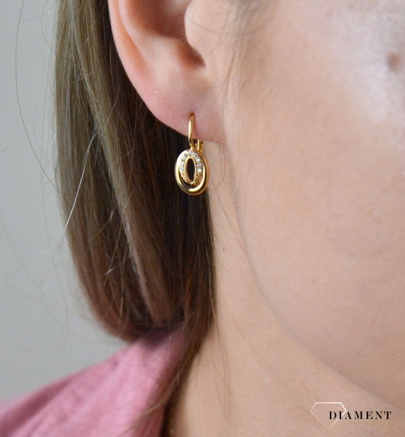 Złote kolczyki 375 wiszące owalne z cyrkoniami DIA-KLC-7764-375. Kolczyki w minimalistycznym stylu, wpisujące się w obecne trendy modowe. Delikatna forma, najwyższej jakości złota to idealne uzupełnienie eleganckich stylizacji.jpg