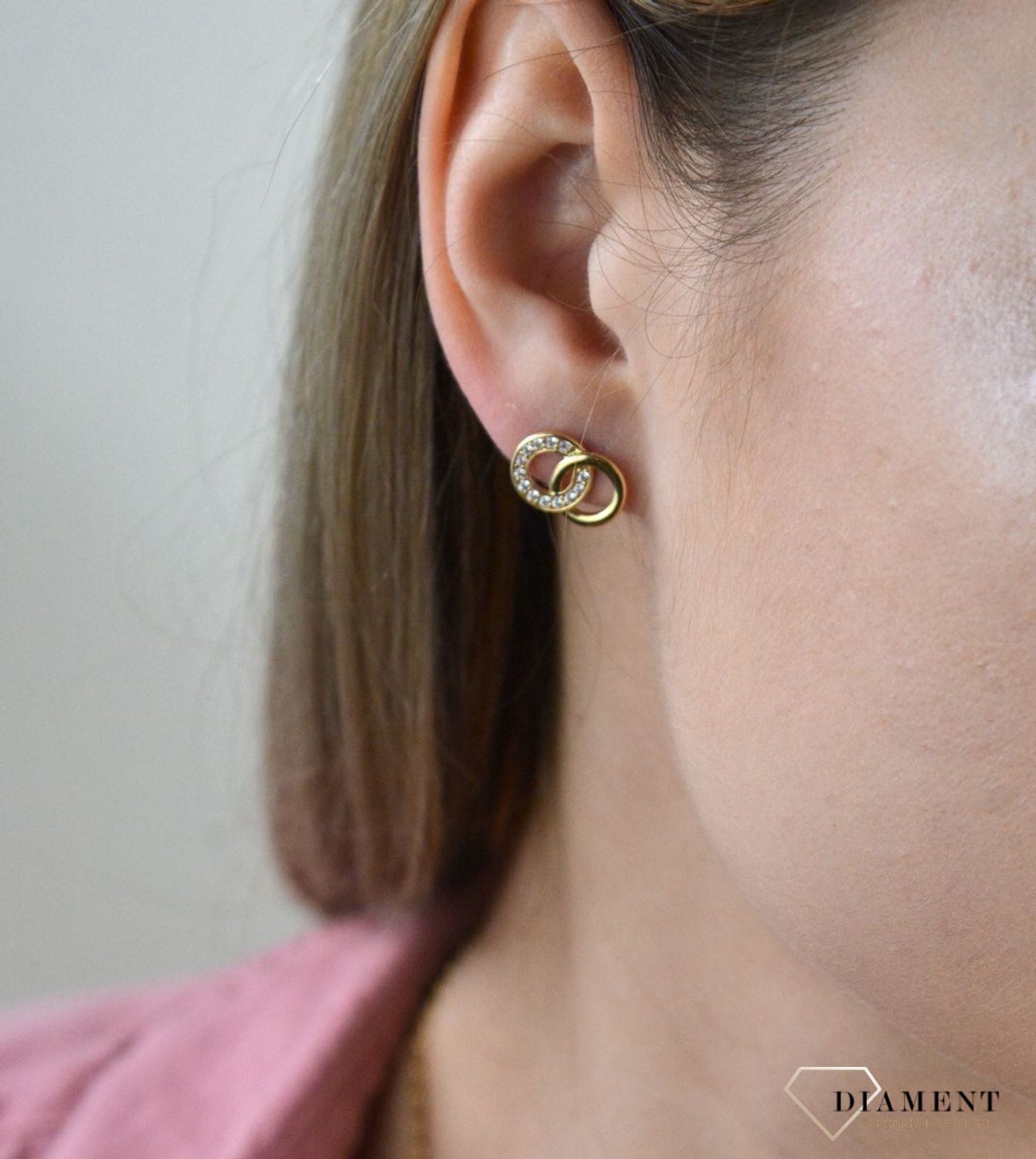 Złote kolczyki 375 połączone kółka z cyrkoniami. Kolczyki pięknie sprawdzą się jako prezent i staną się pamiątką na długie lata. Kolczyki zostały wykonane z złota próba 375. Szerokość kolczyków wynosi 1,3 cm..jpg