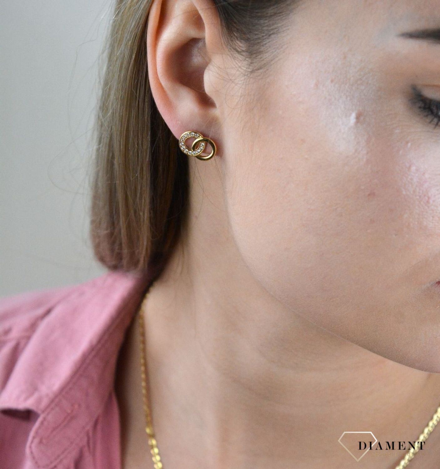 Złote kolczyki 375 połączone kółka z cyrkoniami. Kolczyki pięknie sprawdzą się jako prezent i staną się pamiątką na długie lata. Kolczyki zostały wykonane z złota próba 375. Szerokość kolczyków wynosi 1,3 cm..jpg