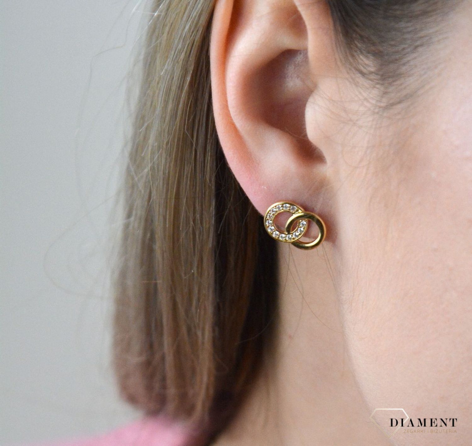Złote kolczyki 375 połączone kółka z cyrkoniami. Kolczyki pięknie sprawdzą się jako prezent i staną się pamiątką na długie lata. Kolczyki zostały wykonane z złota próba 375. Szerokość kolczyków wynosi 1,3 cm..jpg