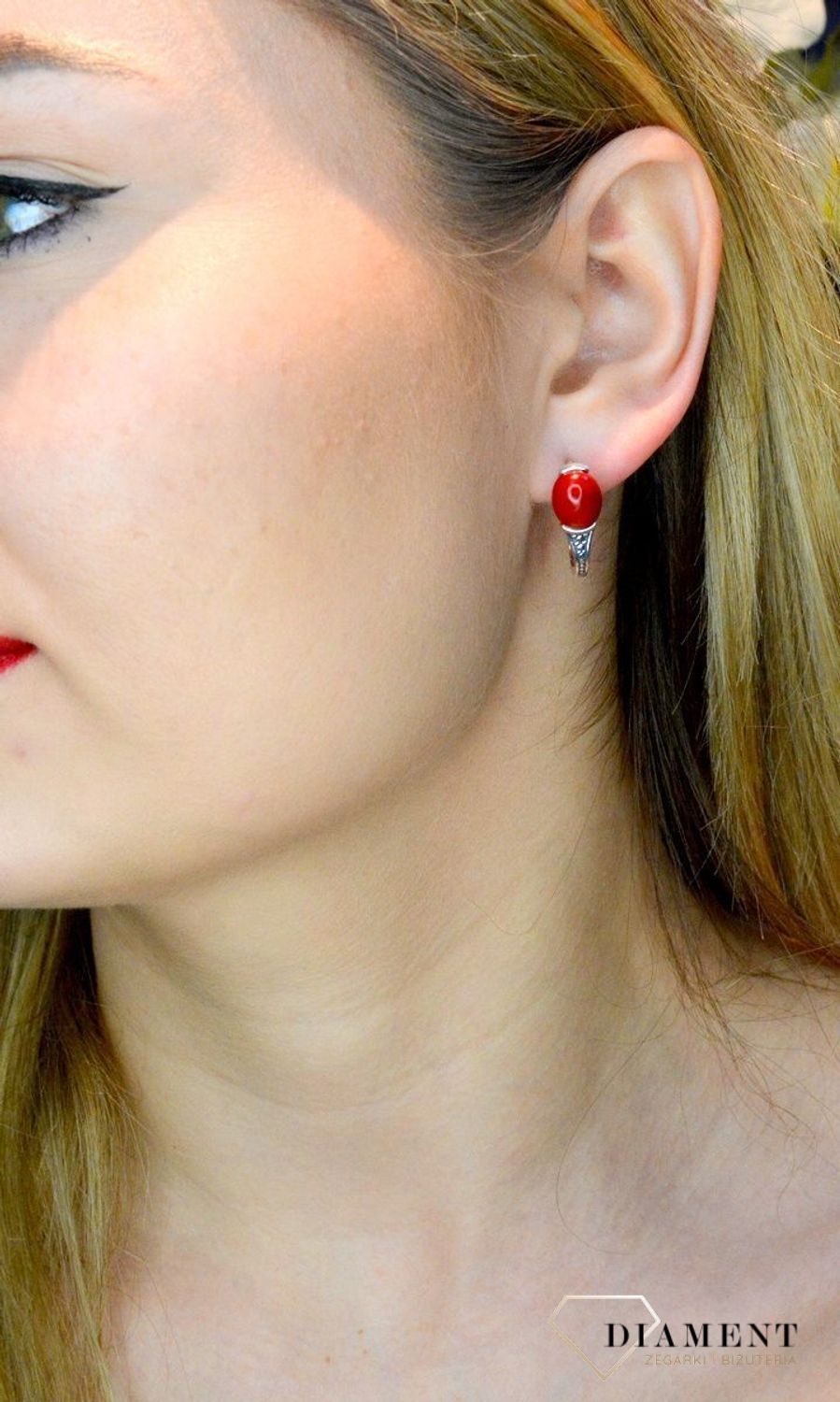 Srebrne kolczyki wiszące z czerwonym oczkiem DIA-KLC-8963-925. Eleganckie kolczyki z kamieniem w owalnym kształcie. Biżuteria wykonana ze srebra próby 925. Efektowne kolczyki zostały ozdobione kamieniem w kolorze koralowym..jpg