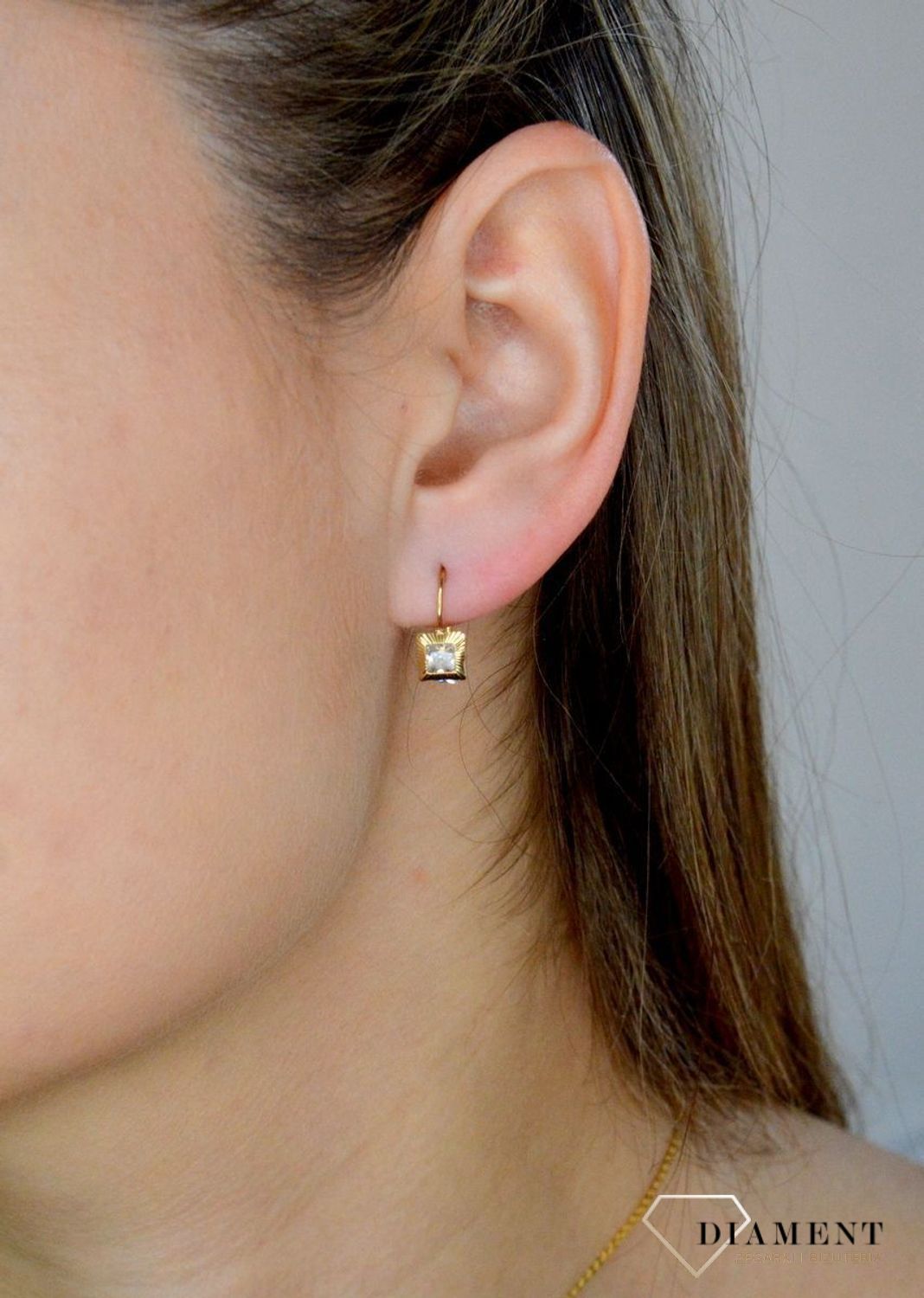 Złote kolczyki 333 wiszące kwadraciki z cyrkonią DIA-KLC-9059-333. Kolczyki zostały wykonane z najwyższej jakości 14-karatowego żółtego złota, próba 333. Kolczyki posiadają wygodne zapięcie na bigiel..jpg