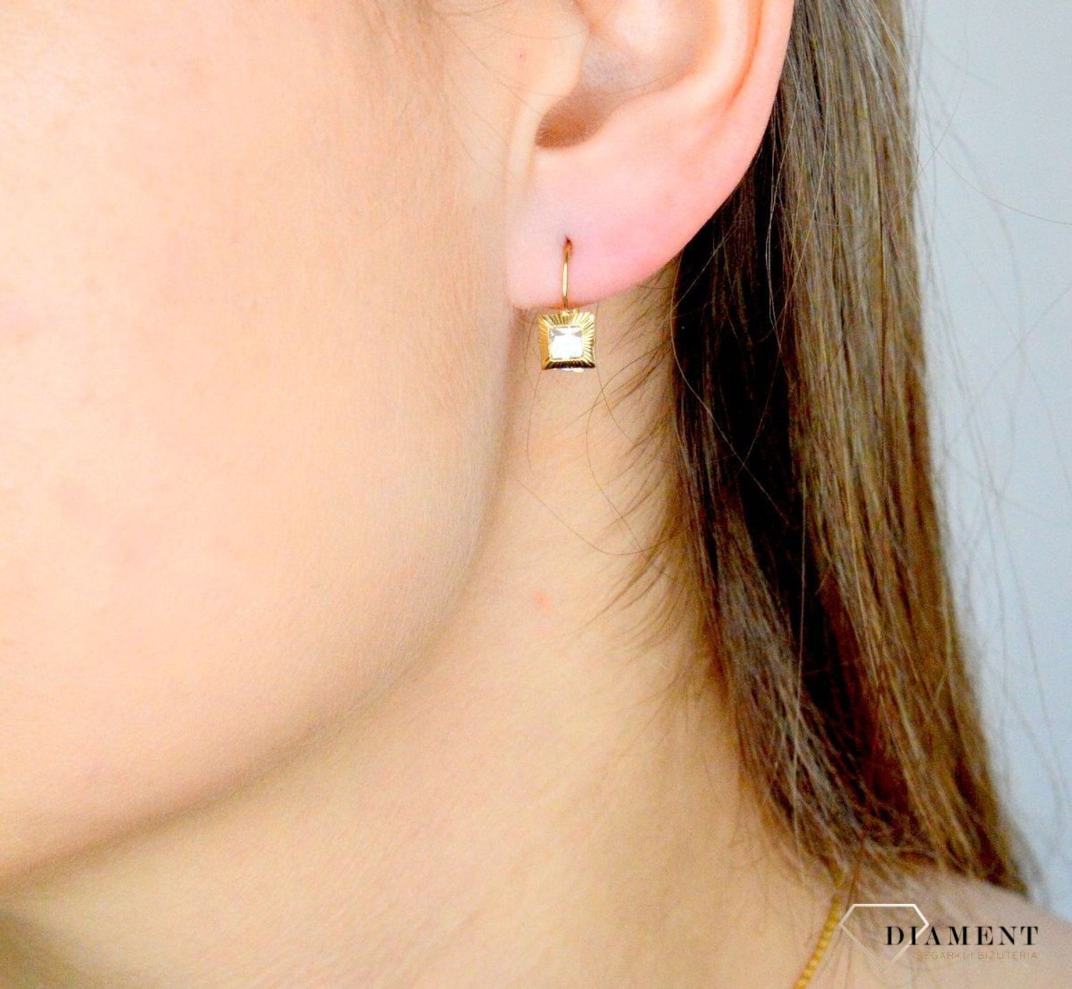 Złote kolczyki 333 wiszące kwadraciki z cyrkonią DIA-KLC-9059-333. Kolczyki zostały wykonane z najwyższej jakości 14-karatowego żółtego złota, próba 333. Kolczyki posiadają wygodne zapięcie na bigiel..jpg