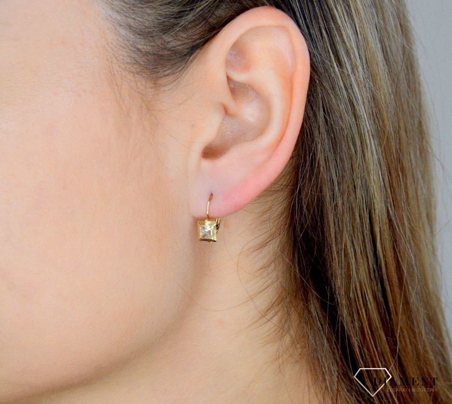 Złote kolczyki 333 wiszące kwadraciki z cyrkonią DIA-KLC-9059-333. Kolczyki zostały wykonane z najwyższej jakości 14-karatowego żółtego złota, próba 333. Kolczyki posiadają wygodne zapięcie na bigiel..jpg