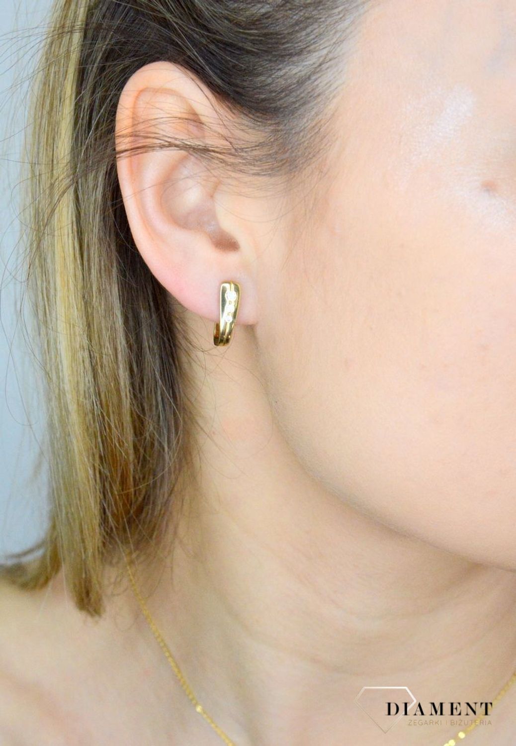 Złote kolczyki 333 ozdobione błyszczącą cyrkonią DIA-KLC-9061-333. Kolczyki to dodatek idealny dla kobiet w każdym wieku. Kolczyki zostały wykonane z złota próba 333 i posiadają wygodne zapięcie angielskie..jpg
