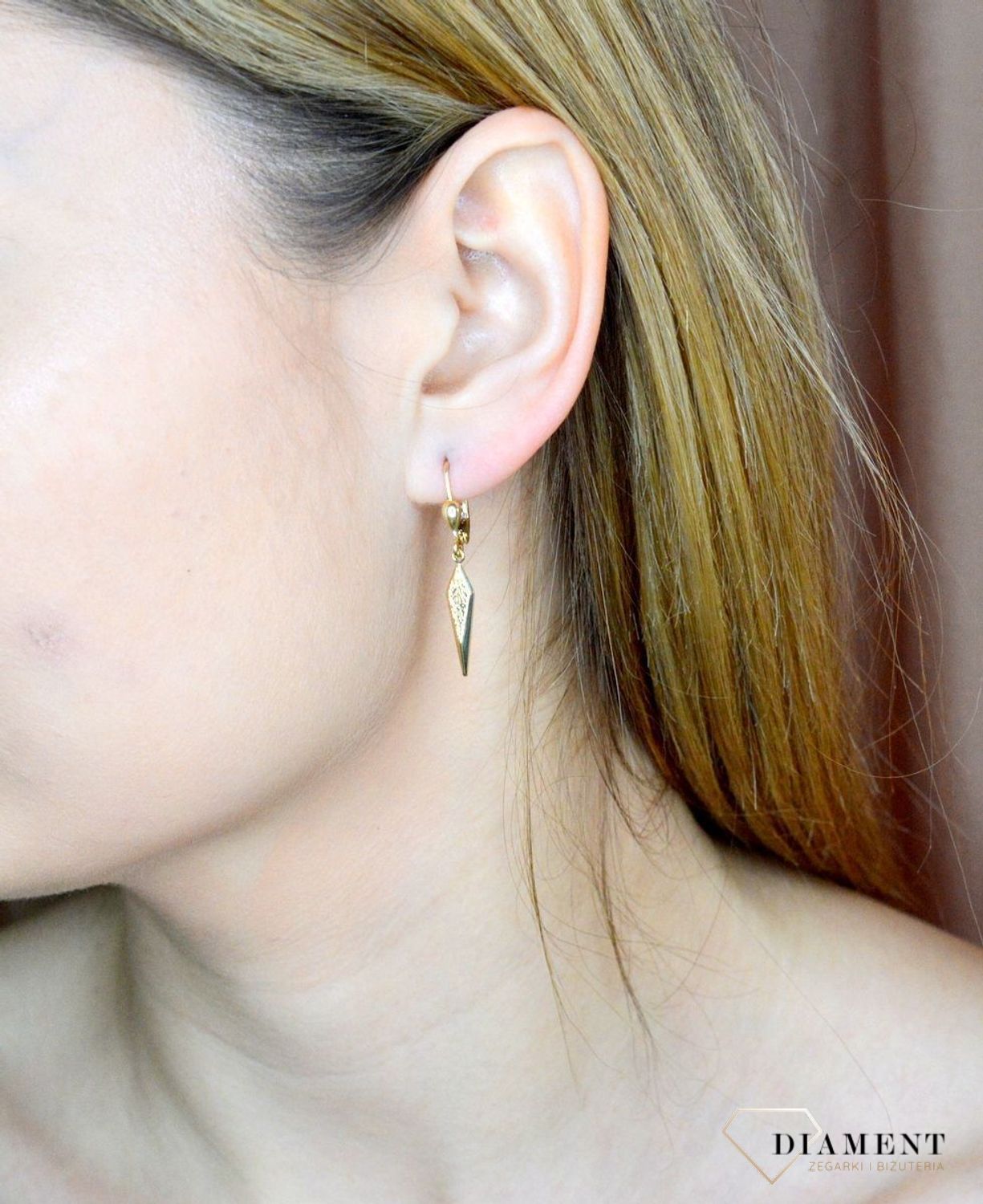 Złote kolczyki 585 wiszące kły z grawerowaniem DIA-KLC-9749-585. Złote kolczyki wykonane z najwyższej jakości żółtego złota, próba 585, waga około 1,66 gram. Kolczyki w minimalistycznym stylu, wpisujące się w obecne trendy modowe. Na.jpg