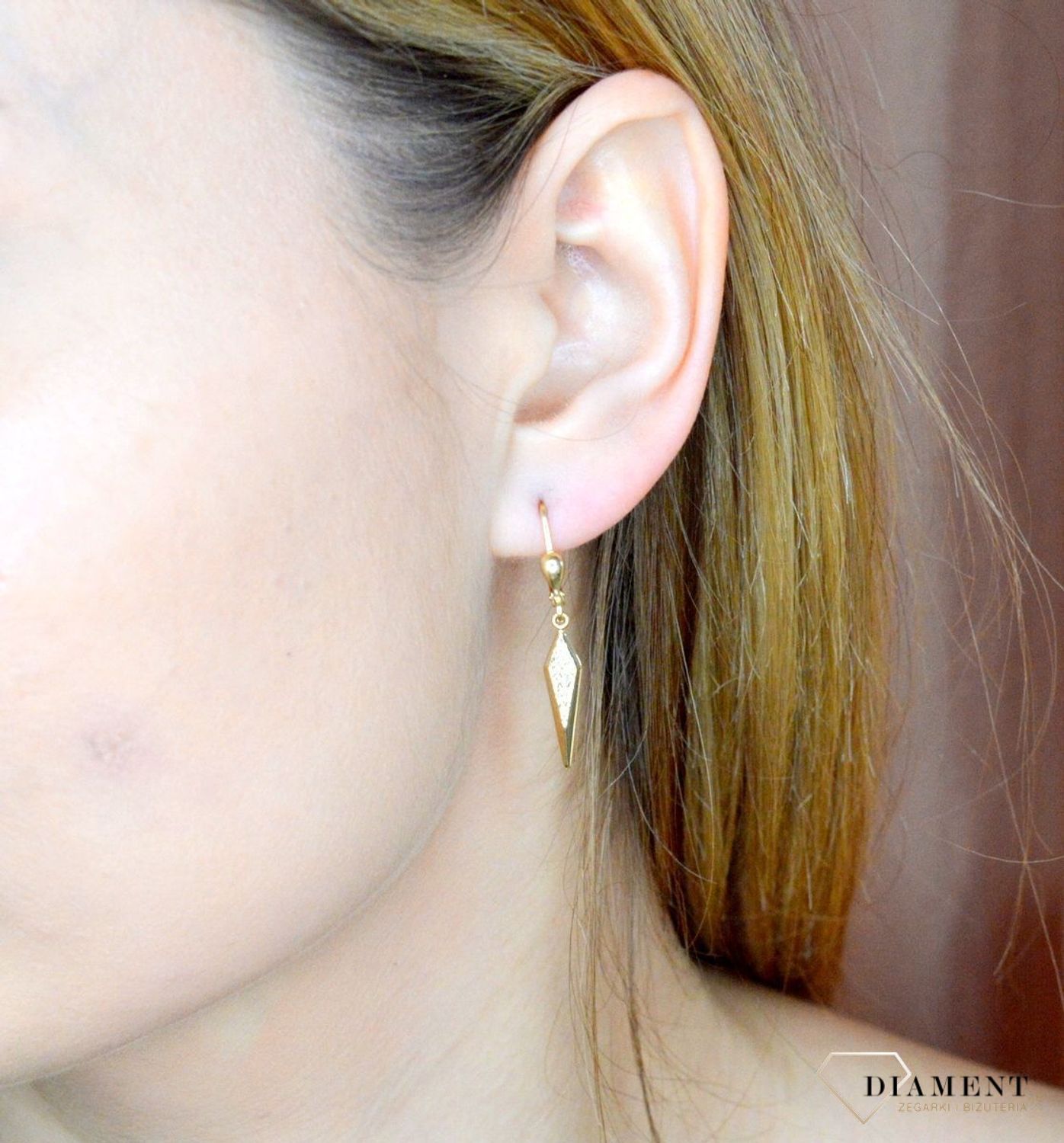 Złote kolczyki 585 wiszące kły z grawerowaniem DIA-KLC-9749-585. Złote kolczyki wykonane z najwyższej jakości żółtego złota, próba 585, waga około 1,66 gram. Kolczyki w minimalistycznym stylu, wpisujące się w obecne trendy modowe. Na.jpg