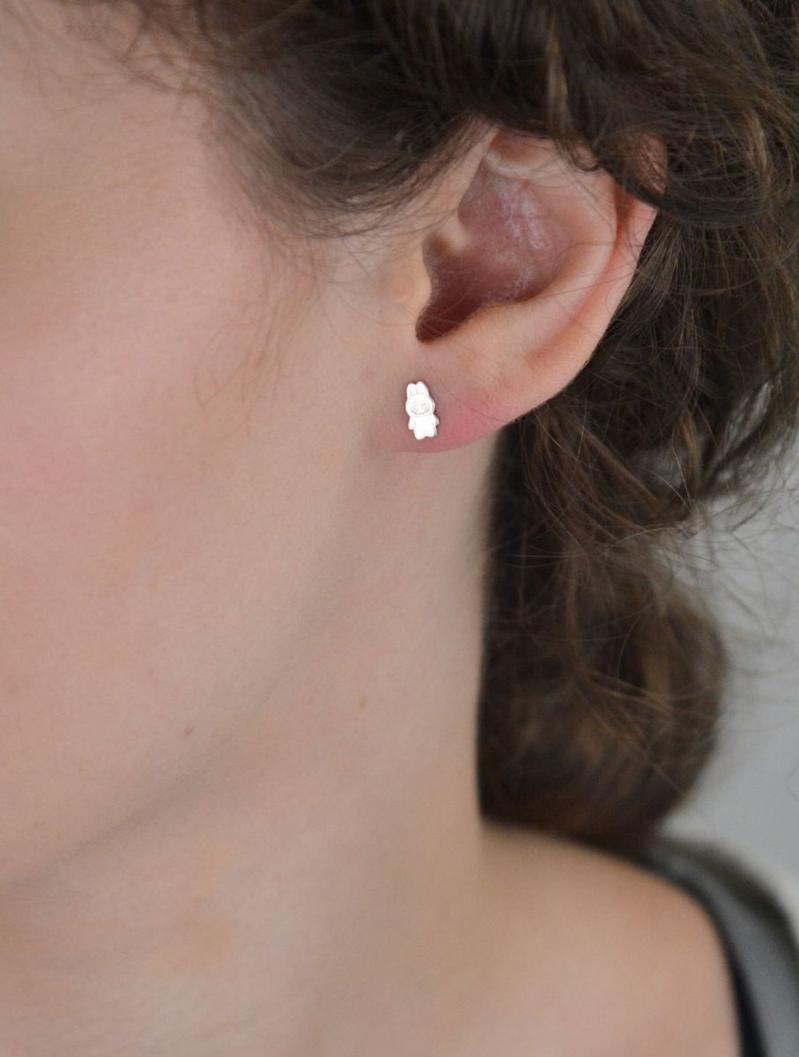 Delikatne kolczyki w kształcie laleczki z rodowanego srebra próby 925. Grawerowane detale, zapięcie na sztyft. Idealne dla dziewczynek i kobiet ceniących oryginalność.1.webp