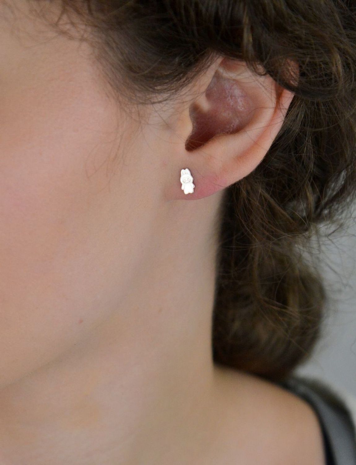Delikatne kolczyki w kształcie laleczki z rodowanego srebra próby 925. Grawerowane detale, zapięcie na sztyft. Idealne dla dziewczynek i kobiet ceniących oryginalność.1.webp