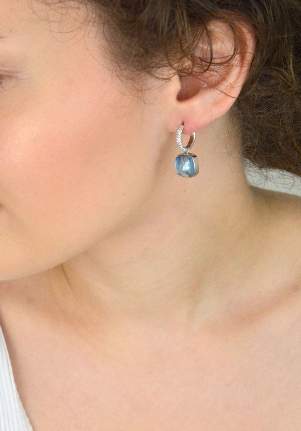 Efektowne kolczyki srebrne 925 z kółeczkami zdobionymi białymi cyrkoniami i wiszącym elementem – niebieska cyrkonia w kształcie kwadratu. Długość 2,5 cm, waga 7,20 g. Model DIA-KLC-SWAROVSKIblue.jpg