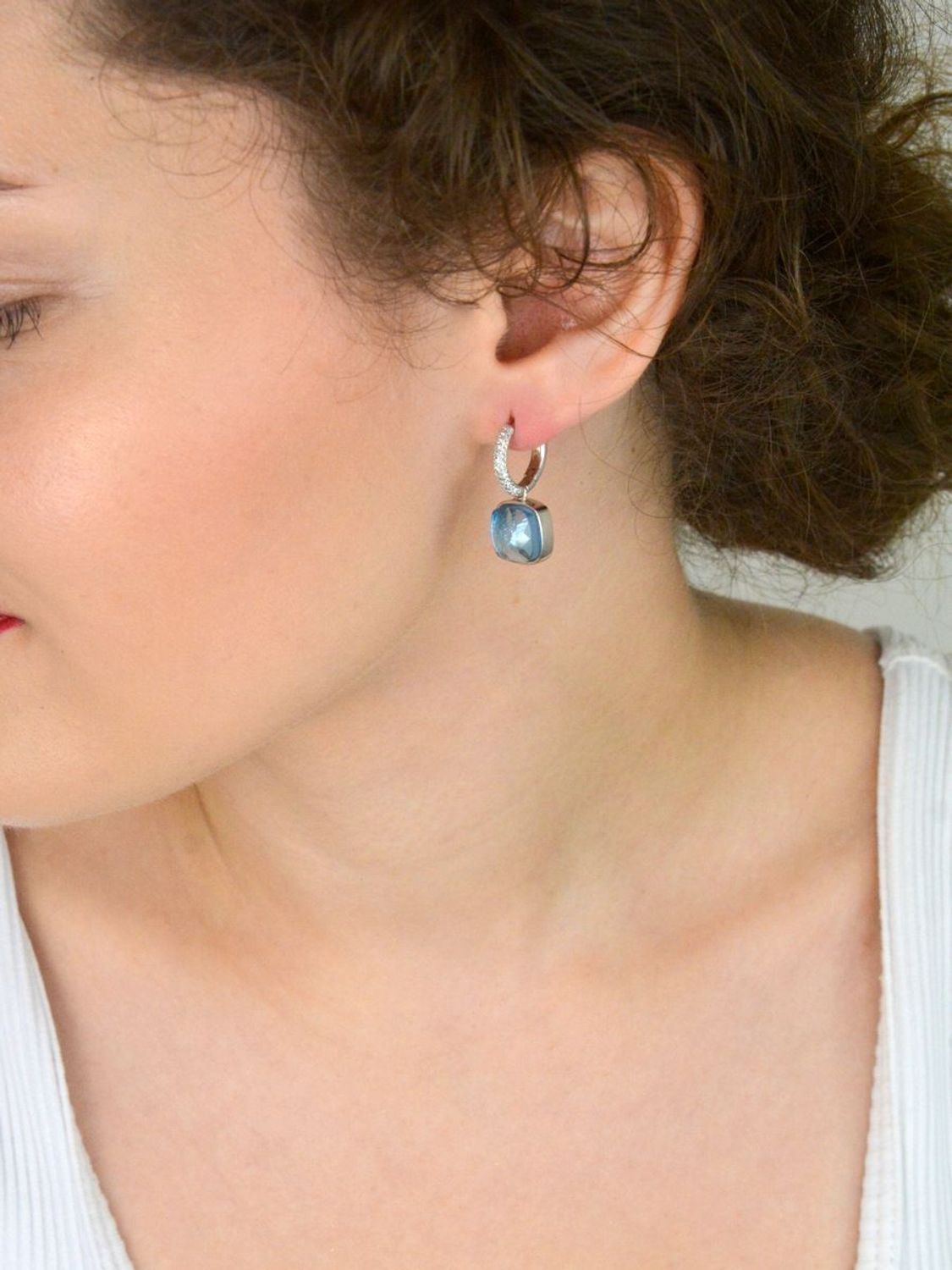 Efektowne kolczyki srebrne 925 z kółeczkami zdobionymi białymi cyrkoniami i wiszącym elementem – niebieska cyrkonia w kształcie kwadratu. Długość 2,5 cm, waga 7,20 g. Model DIA-KLC-SWAROVSKIblue.jpg