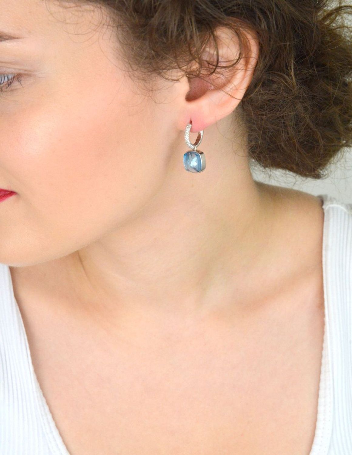 Efektowne kolczyki srebrne 925 z kółeczkami zdobionymi białymi cyrkoniami i wiszącym elementem – niebieska cyrkonia w kształcie kwadratu. Długość 2,5 cm, waga 7,20 g. Model DIA-KLC-SWAROVSKIblue.jpg