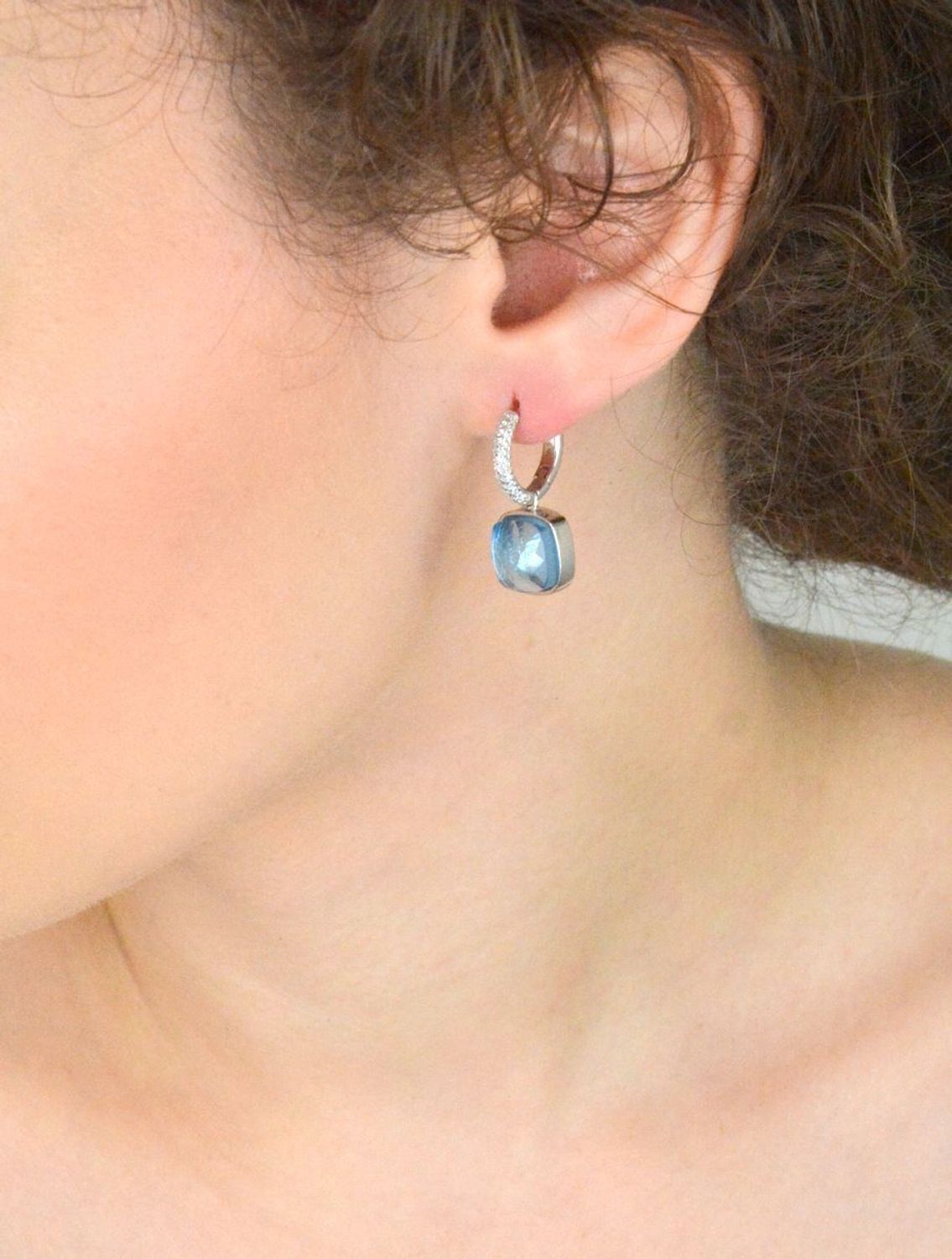 Efektowne kolczyki srebrne 925 z kółeczkami zdobionymi białymi cyrkoniami i wiszącym elementem – niebieska cyrkonia w kształcie kwadratu. Długość 2,5 cm, waga 7,20 g. Model DIA-KLC-SWAROVSKIblue.jpg