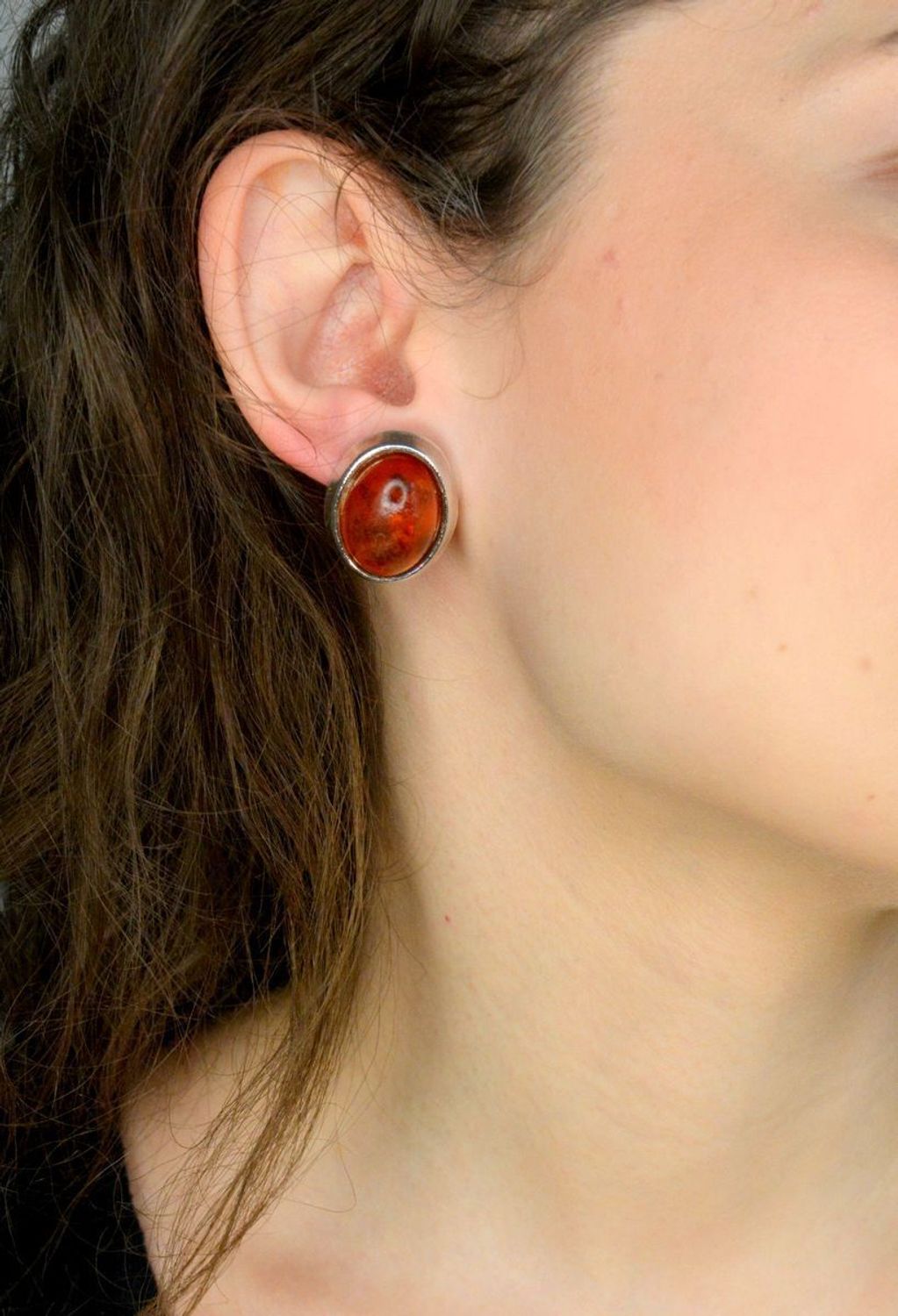 Klipsy srebrne bursztyn próba 925, DIA-KLI-12603-925 Srebrne klipsy zostały wykonane z najwyższej jakości srebra próby 925. Kolczyki zostały starannie ozdobione bursztynem bałtyckim w brązowym kolorze o owalnym kształcie. 1.jpg