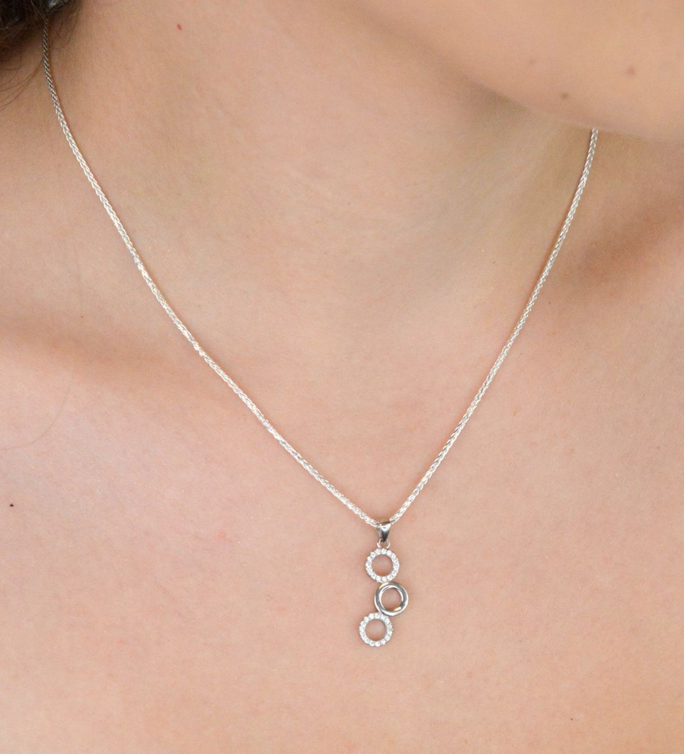 Elegancki srebrny komplet DIA-KPL-11828-925 z potrójnymi kółeczkami i błyszczącymi cyrkoniami. Kolczyki z wygodnym zapięciem na bigiel. Waga 4,60 g, długość kolczyków 3,8 cm, zawieszka 2,2 cm.3.jpg