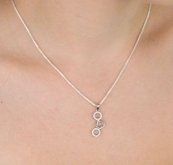 Elegancki srebrny komplet DIA-KPL-11828-925 z potrójnymi kółeczkami i błyszczącymi cyrkoniami. Kolczyki z wygodnym zapięciem na bigiel. Waga 4,60 g, długość kolczyków 3,8 cm, zawieszka 2,2 cm (1).JPG