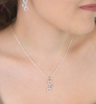 Elegancki srebrny komplet DIA-KPL-11828-925 z potrójnymi kółeczkami i błyszczącymi cyrkoniami. Kolczyki z wygodnym zapięciem na bigiel. Waga 4,60 g, długość kolczyków 3,8 cm, zawieszka 2,2 cm (6).JPG