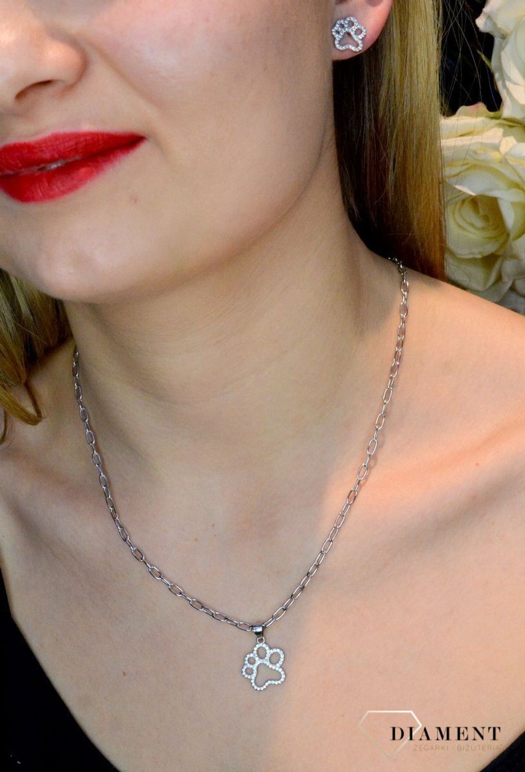 Srebrny komplet zawieszka i kolczyki łapka psa w cyrkoniach DIA-KPL-53561-925. Piękny komplet srebrnej biżuterii to idealna propozycja na prezent dla miłośnika psów. W skład kompletu wchodzą delikatne kolczyki na sztyft i wisi.jpg