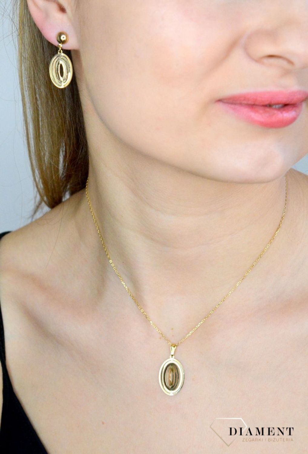 Komplet złotej biżuterii 333 zawieszka i kolczyki w owalnym kształcie DIA-KPL-9144-333. Piękny komplet złotej biżuterii to idealna propozycja na prezent dla ukochanej kobiety. W skład kompletu wchodzą delikatne kolczyki wisząc.jpg