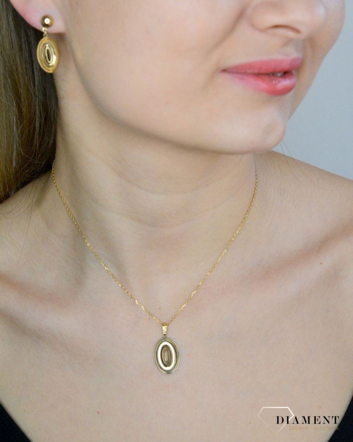 Komplet złotej biżuterii 333 zawieszka i kolczyki w owalnym kształcie DIA-KPL-9144-333. Piękny komplet złotej biżuterii to idealna propozycja na prezent dla ukochanej kobiety. W skład kompletu wchodzą delikatne kolczyki wisząc.jpg