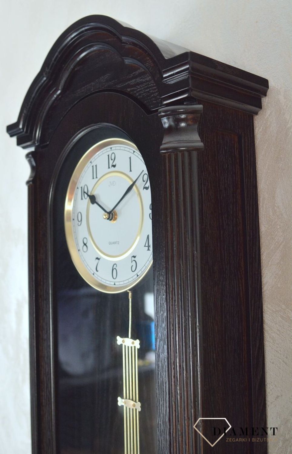 Zegar ścienny z wahadłem ' Drewniany zegar' JVD N9353.1 wyposażony jest w kwarcowy mechanizm, zasilany za pomocą baterii. Posiada bardzo wysoką dokładność mierzenia czasu +- 10 sekund w przeciągu 30 dni..png