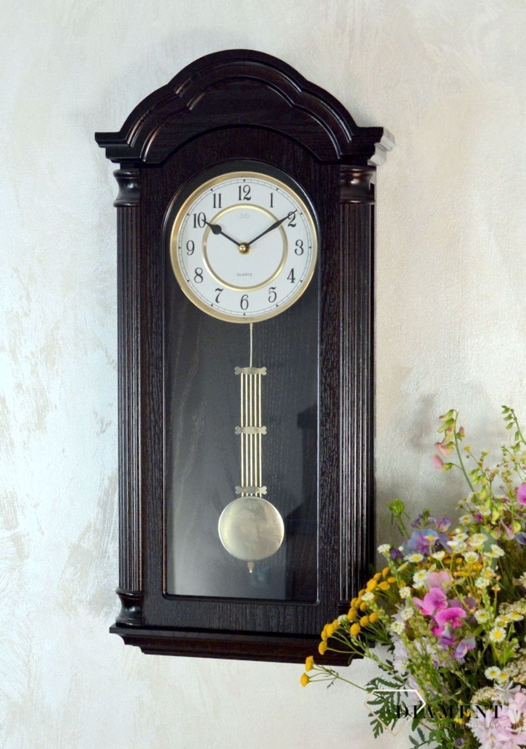 Zegar ścienny z wahadłem ' Drewniany zegar' JVD N9353.1 wyposażony jest w kwarcowy mechanizm, zasilany za pomocą baterii. Posiada bardzo wysoką dokładność mierzenia czasu +- 10 sekund w przeciągu 30 dni..png