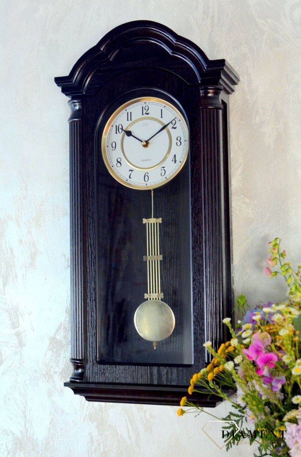 Zegar ścienny z wahadłem ' Drewniany zegar' JVD N9353.1 wyposażony jest w kwarcowy mechanizm, zasilany za pomocą baterii. Posiada bardzo wysoką dokładność mierzenia czasu +- 10 sekund w przeciągu 30 dni..png