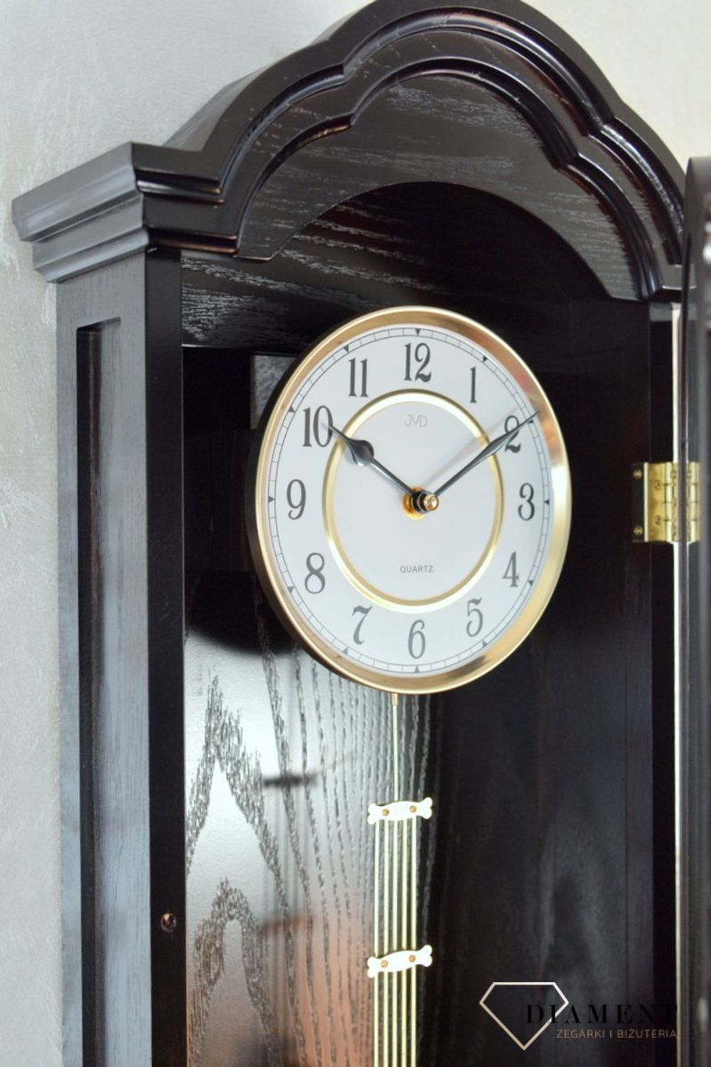 Zegar ścienny z wahadłem ' Drewniany zegar' JVD N9353.1 wyposażony jest w kwarcowy mechanizm, zasilany za pomocą baterii. Posiada bardzo wysoką dokładność mierzenia czasu +- 10 sekund w przeciągu 30 dni..png