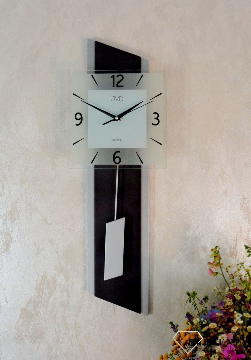 Zegar ścienny wahadłowy JVD NS19052.2 wyposażony jest w kwarcowy mechanizm, zasilany za pomocą baterii. Posiada bardzo wysoką dokładność mierzenia czasu +- 10 sekund w przeciągu 30 dni.jpg