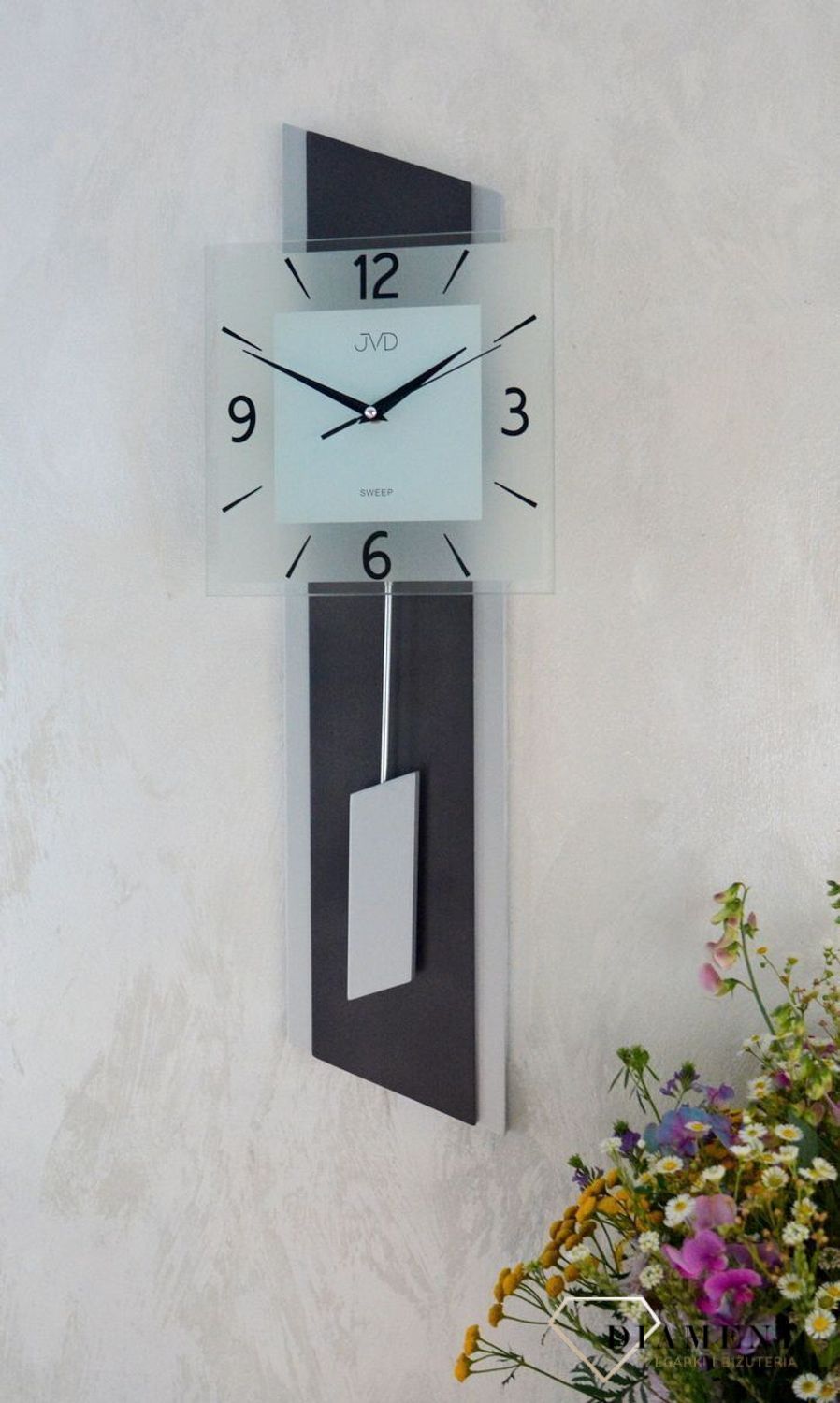 Zegar ścienny wahadłowy JVD NS19052.2 wyposażony jest w kwarcowy mechanizm, zasilany za pomocą baterii. Posiada bardzo wysoką dokładność mierzenia czasu +- 10 sekund w przeciągu 30 dni.jpg