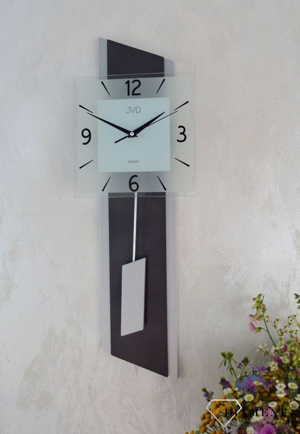 Zegar ścienny wahadłowy JVD NS19052.2 wyposażony jest w kwarcowy mechanizm, zasilany za pomocą baterii. Posiada bardzo wysoką dokładność mierzenia czasu +- 10 sekund w przeciągu 30 dni.jpg