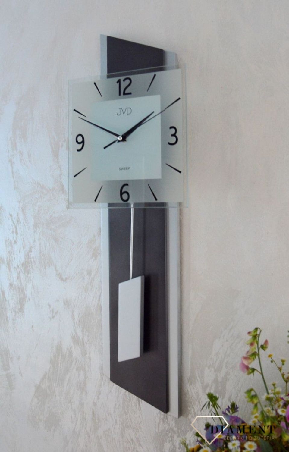 Zegar ścienny wahadłowy JVD NS19052.2 wyposażony jest w kwarcowy mechanizm, zasilany za pomocą baterii. Posiada bardzo wysoką dokładność mierzenia czasu +- 10 sekund w przeciągu 30 dni.jpg