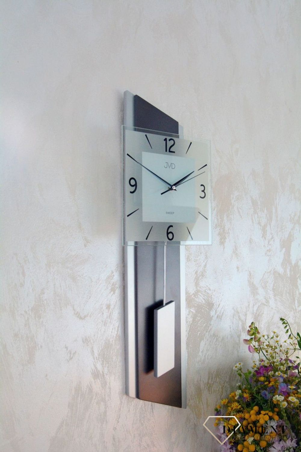 Zegar ścienny wahadłowy JVD NS19052.2 wyposażony jest w kwarcowy mechanizm, zasilany za pomocą baterii. Posiada bardzo wysoką dokładność mierzenia czasu +- 10 sekund w przeciągu 30 dni.jpg