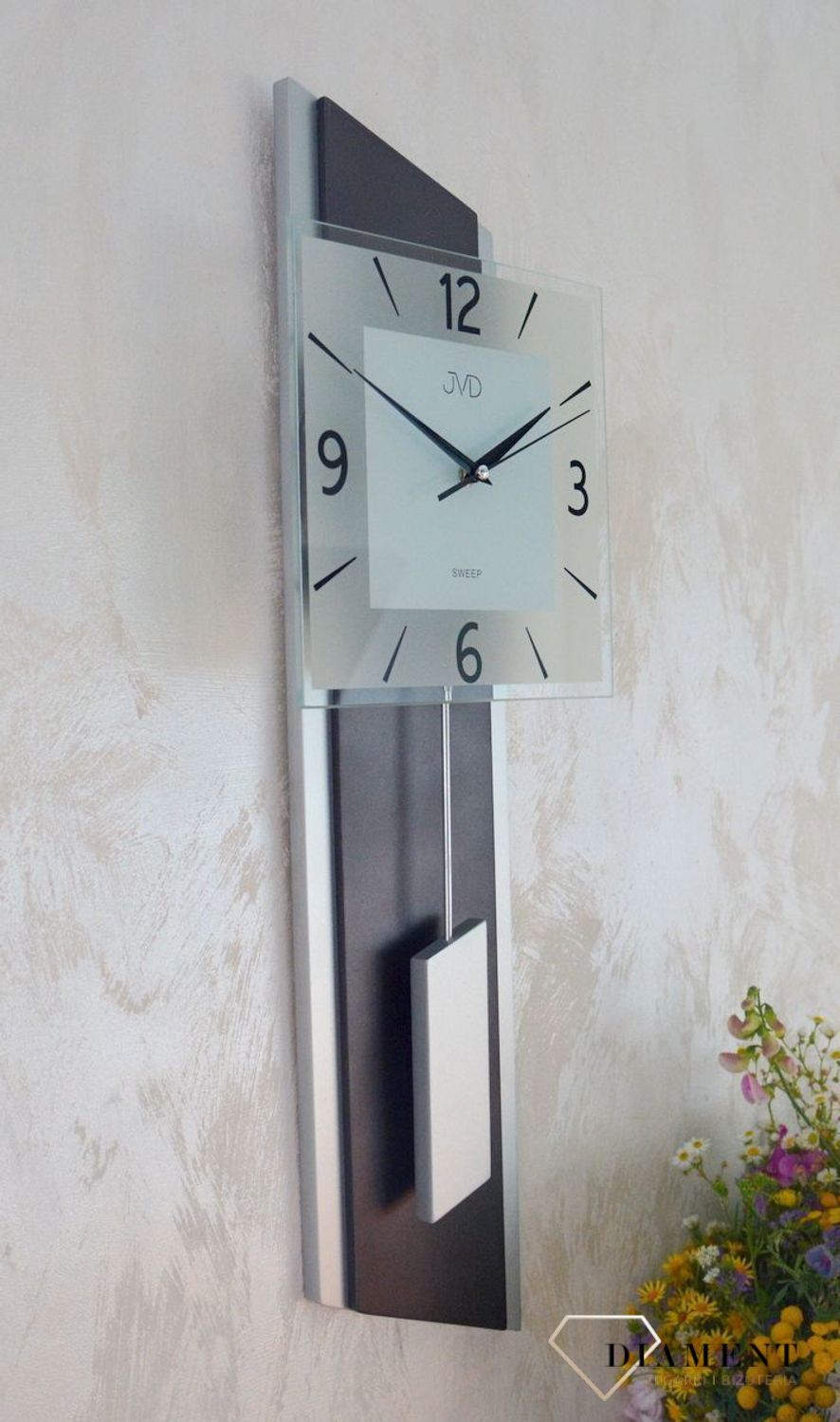 Zegar ścienny wahadłowy JVD NS19052.2 wyposażony jest w kwarcowy mechanizm, zasilany za pomocą baterii. Posiada bardzo wysoką dokładność mierzenia czasu +- 10 sekund w przeciągu 30 dni.jpg