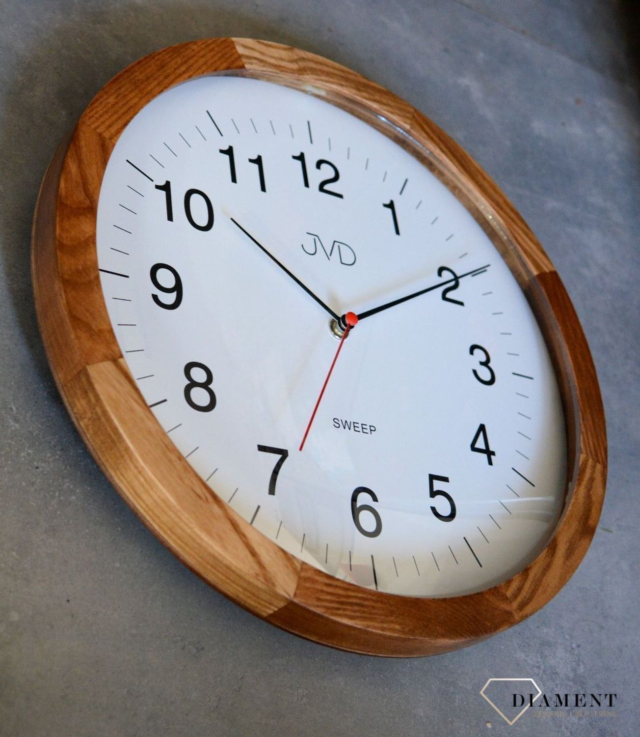 Zegar ścienny drewniany JVD NS22009.78 .  Nowoczesny zegar na ścianę NS22009.78 wyposażony jest w kwarcowy mechanizm, zasilany za pomocą baterii. Posiada bardzo wysoką dokładność mierzenia czasu +- 10 sekund w przeciągu 30 dni..jpg