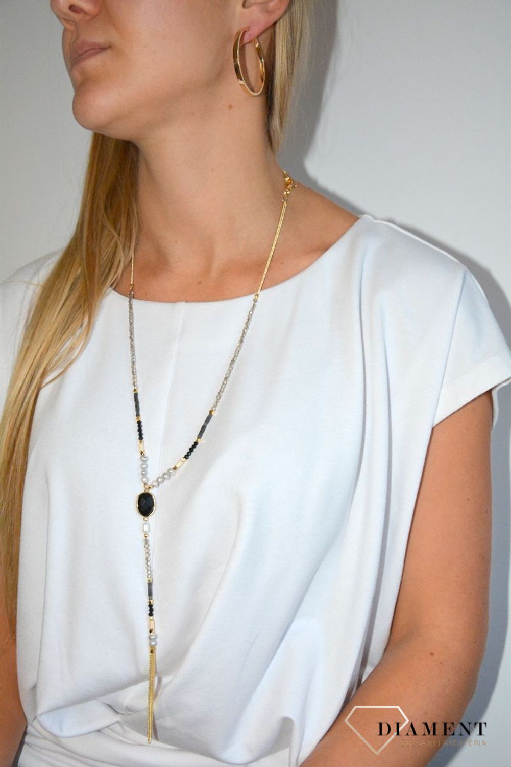 Długi naszyjnik w kolorze złota z elementami ozdobnymi.jpg