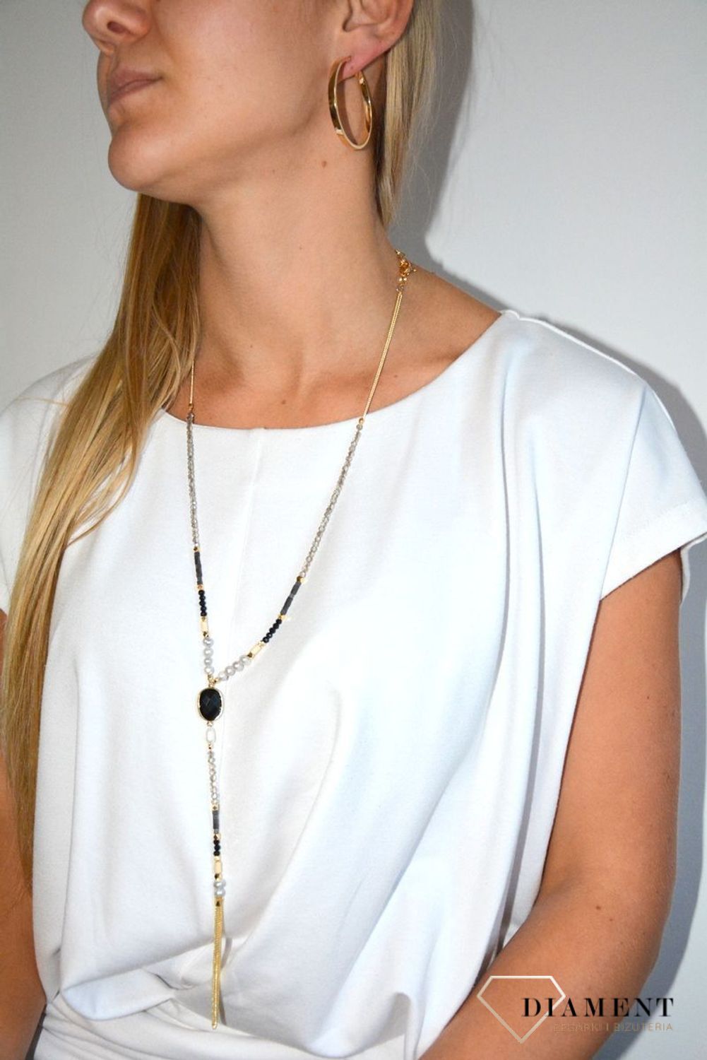 Długi naszyjnik w kolorze złota z elementami ozdobnymi.jpg