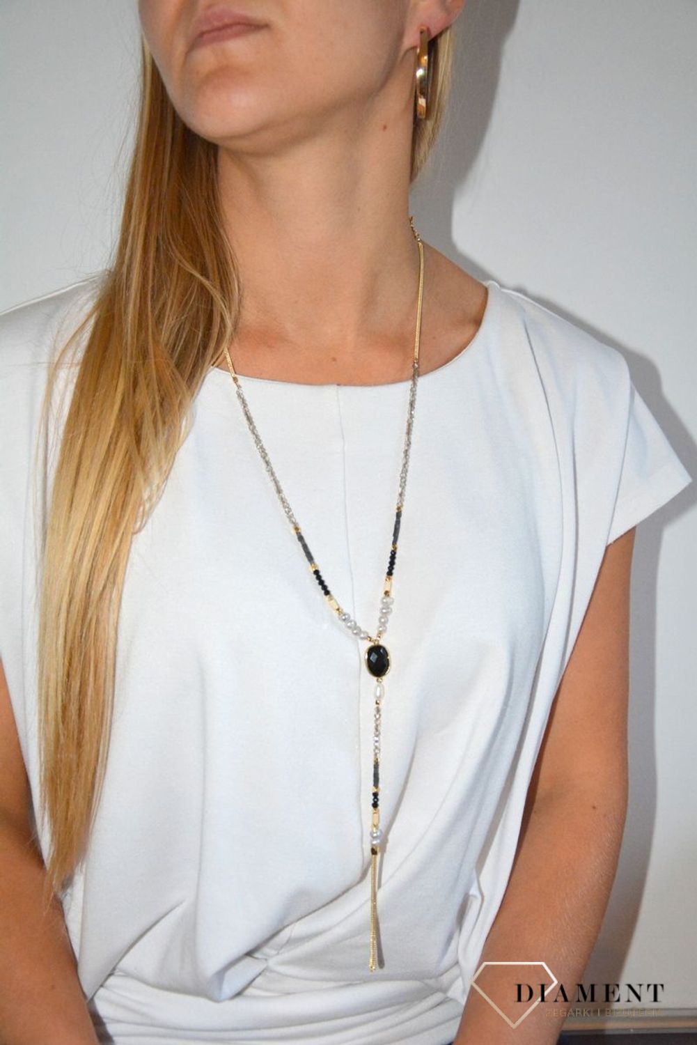 Długi naszyjnik w kolorze złota z elementami ozdobnymi.jpg