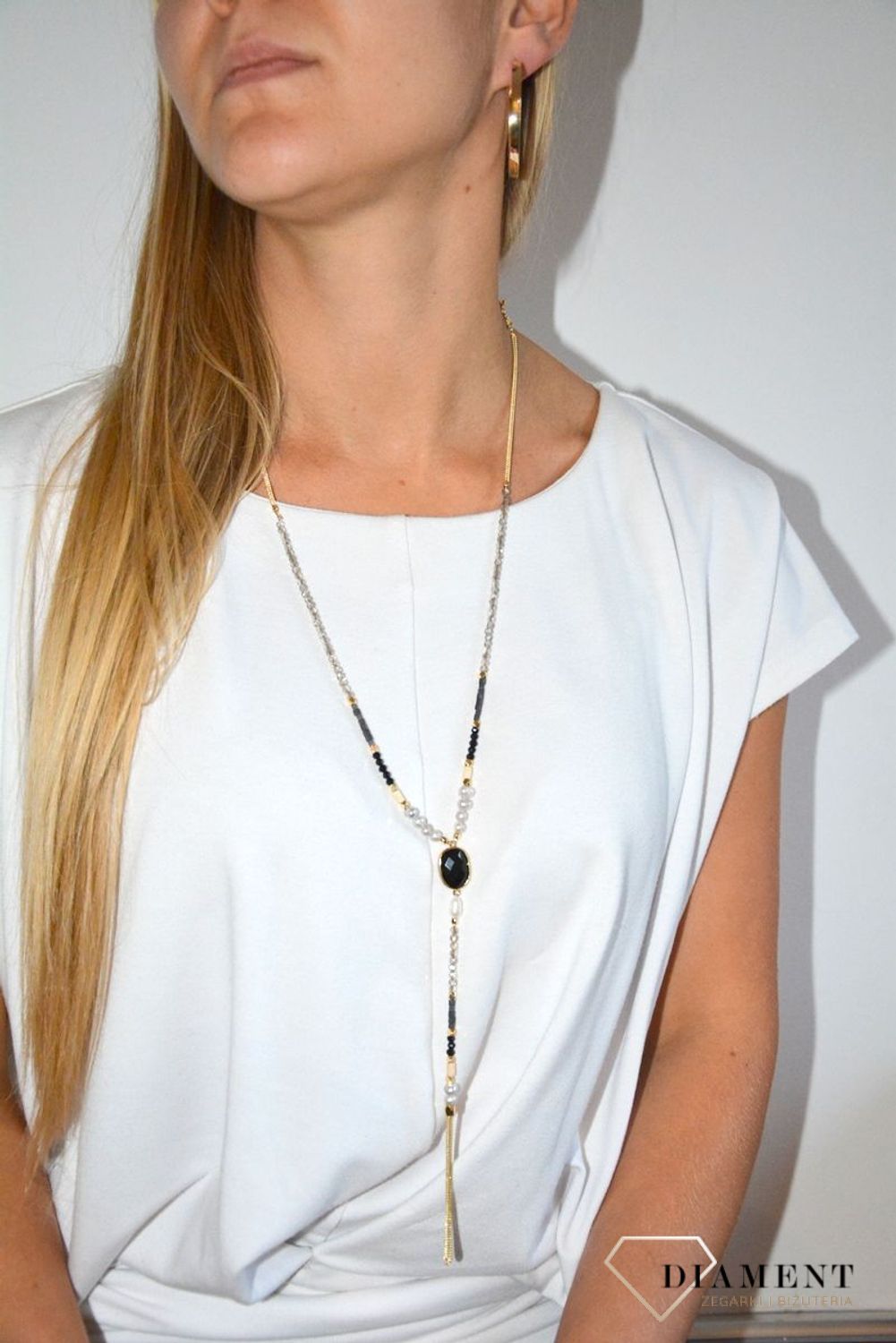 Długi naszyjnik w kolorze złota z elementami ozdobnymi.jpg