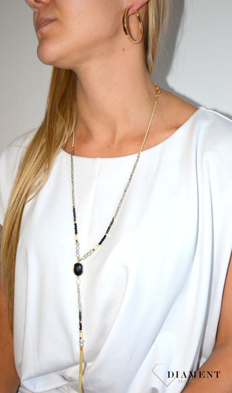 Długi naszyjnik w kolorze złota z elementami ozdobnymi.jpg