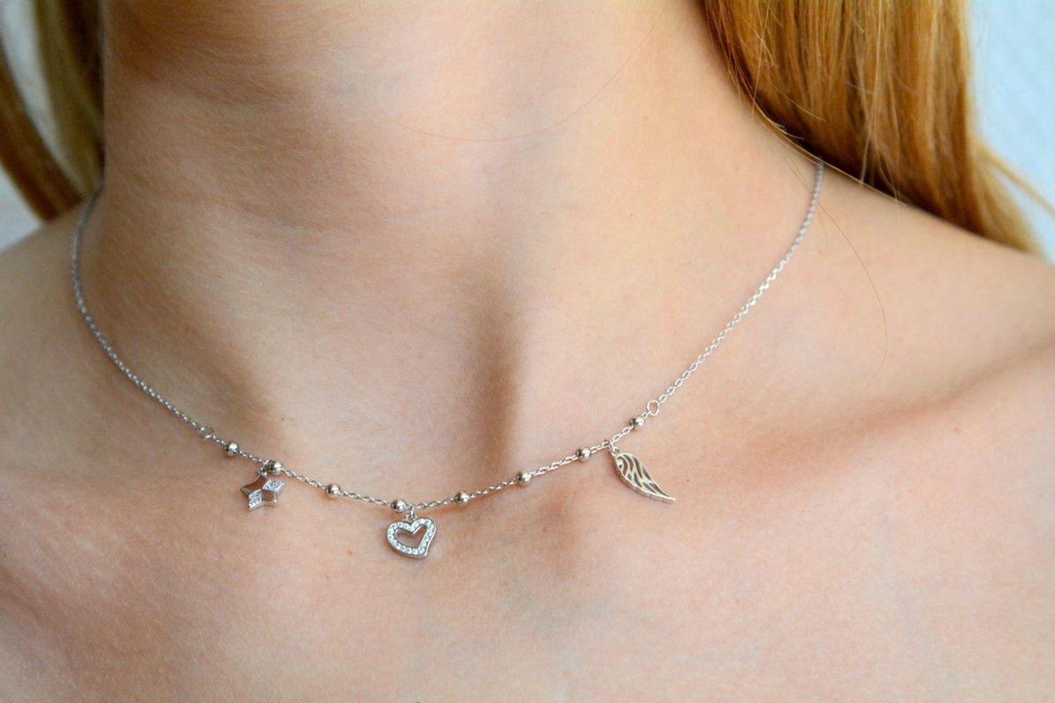 Naszyjnik srebrny damski celebrytka z wiszącymi elementami i kuleczkami DIA-NSZ-2225-925. Naszyjnik wykonany z najwyższej próby srebra z ozdobnym splotem łańcuszka z wiszącymi elementami tj.skrzydełko, serduszko, gwiazdka. C.jpg