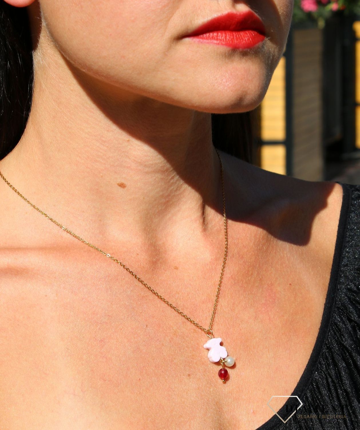 Stalowy pozłacany naszyjnik z różowym misiem i koralikami DIA-NSZ-3310-STAL. Elementem ozdobnym w naszyjniku jest zawieszka w kształcie misia w kolorze różowym oraz dołączone do niego koraliki w kolorze białym (1).JPG