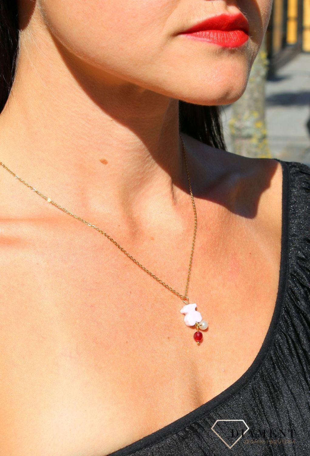 Stalowy pozłacany naszyjnik z różowym misiem i koralikami DIA-NSZ-3310-STAL. Elementem ozdobnym w naszyjniku jest zawieszka w kształcie misia w kolorze różowym oraz dołączone do niego koraliki w kolorze białym (1).JPG