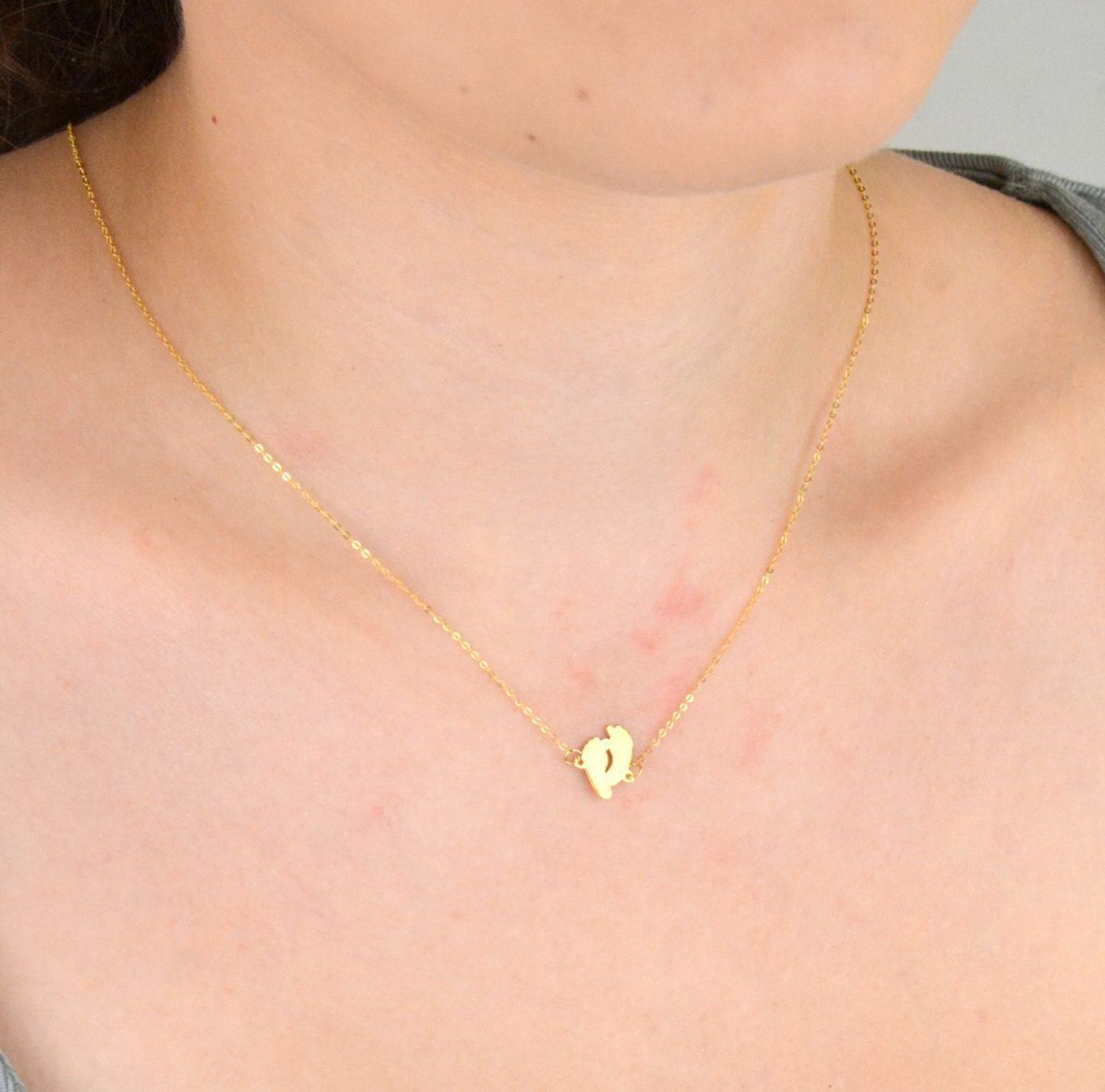 Złoty naszyjnik damski próby 333 z zawieszką w kształcie dwóch gładkich stópek. Długość 42+3 cm, splot ankier, waga 0,90 g. Symboliczna i delikatna biżuteria o wyjątkowym znaczeniu.1.jpg