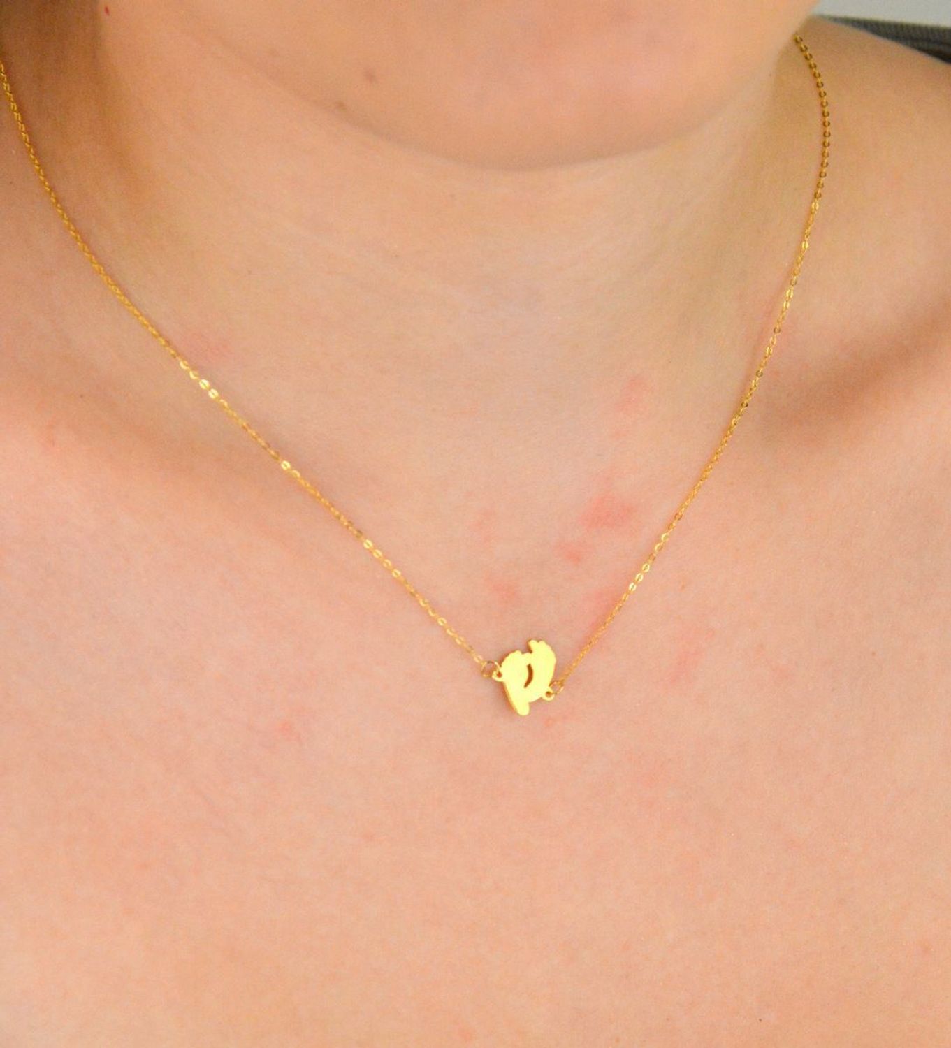 Złoty naszyjnik damski próby 333 z zawieszką w kształcie dwóch gładkich stópek. Długość 42+3 cm, splot ankier, waga 0,90 g. Symboliczna i delikatna biżuteria o wyjątkowym znaczeniu.1.jpg