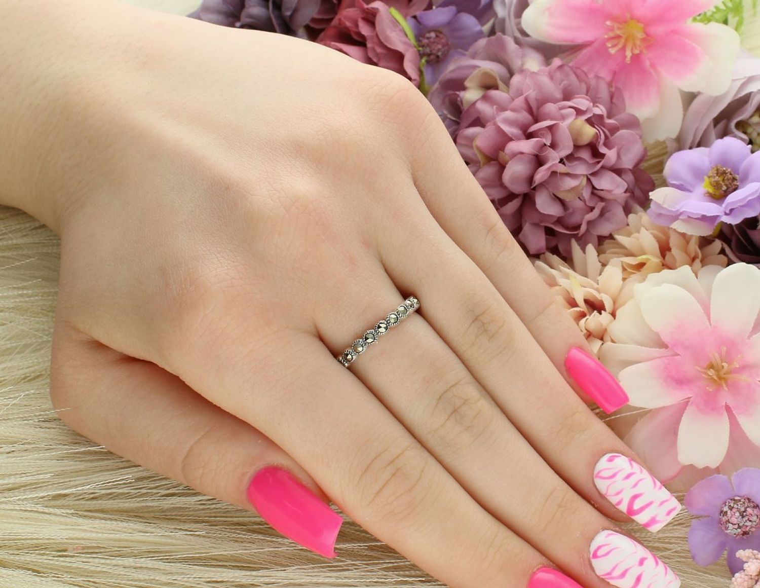 Delikatny pierścionek srebrny próby 925 w formie obrączki, zdobiony markazytami i syntetycznymi szmaragdami. Lekki i wygodny – 2,72 g, szerokość 2 mm.1.jpg